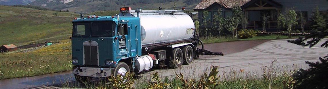 Tanker truck applying Coherex dust suppressant and soil stabilizer