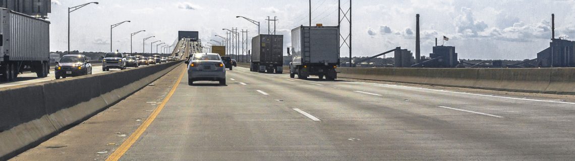 Trucks and cars traveling on a concrete bridge